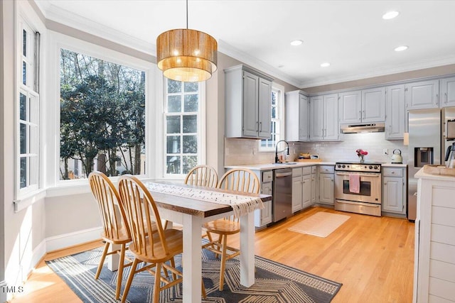 kitchen with gray cabinetry, light countertops, appliances with stainless steel finishes, ornamental molding, and pendant lighting