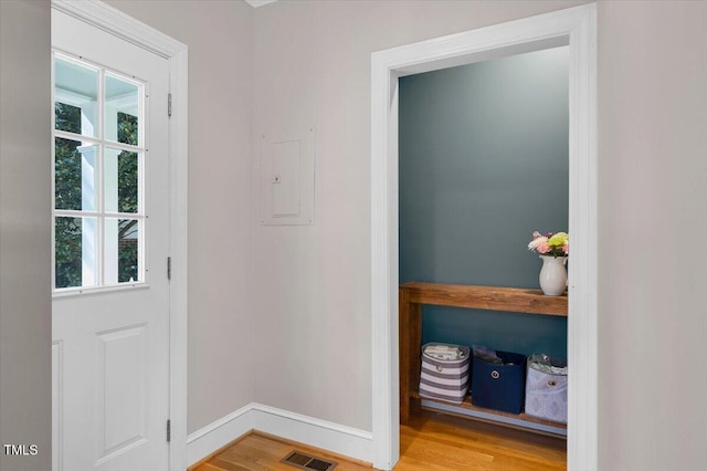 doorway to outside with baseboards, wood finished floors, visible vents, and a healthy amount of sunlight