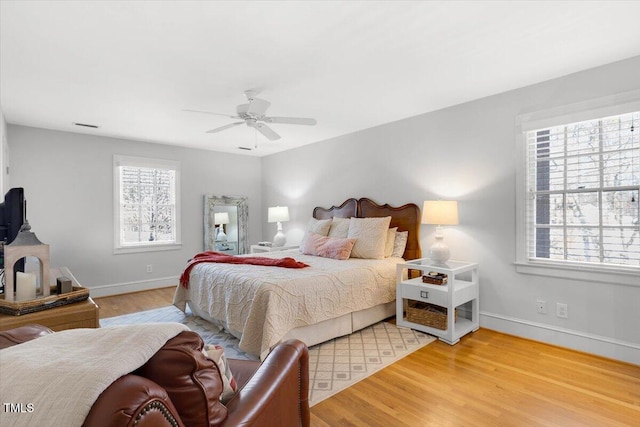 bedroom featuring ceiling fan, baseboards, and wood finished floors