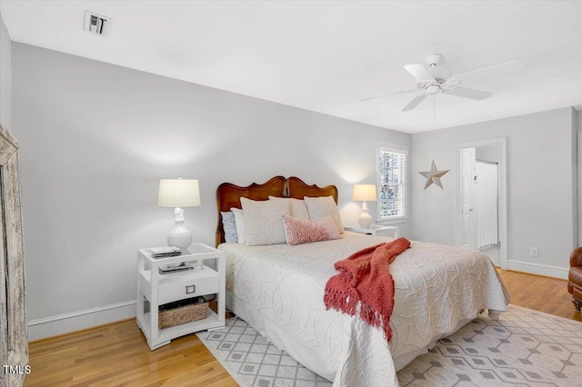 bedroom with visible vents, baseboards, and wood finished floors