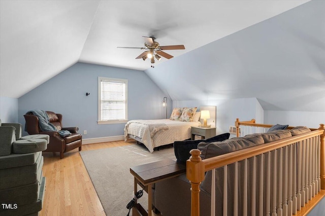 bedroom with lofted ceiling, light wood-style flooring, baseboards, and a ceiling fan