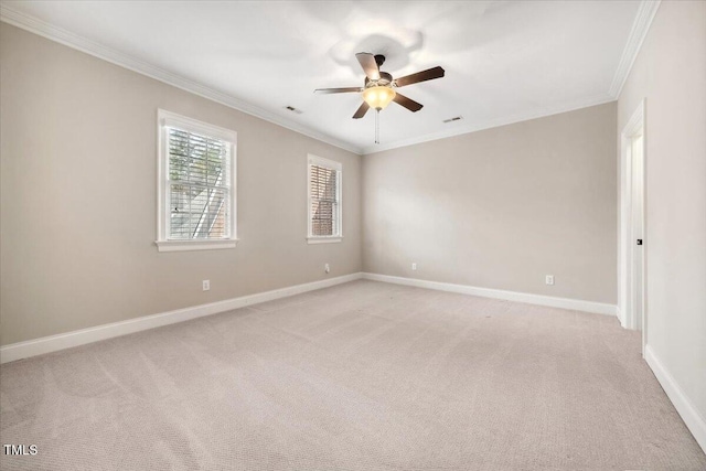 empty room with light carpet, crown molding, and baseboards