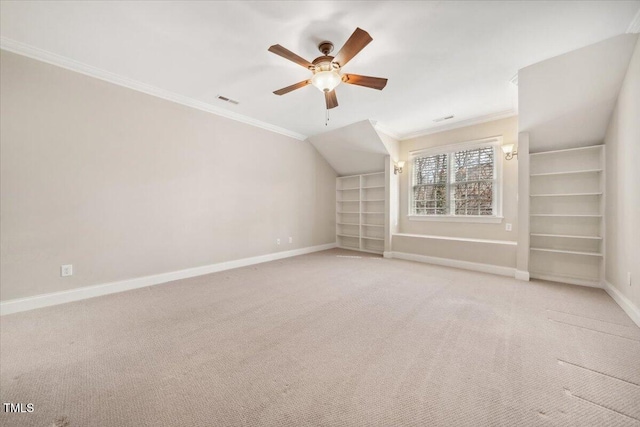 additional living space featuring built in features, visible vents, a ceiling fan, baseboards, and carpet flooring