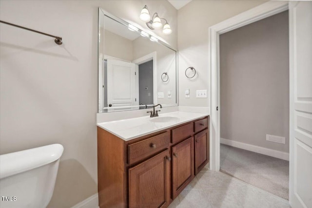 bathroom featuring tile patterned flooring, baseboards, vanity, and toilet