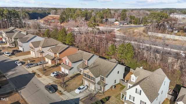 drone / aerial view with a wooded view and a residential view