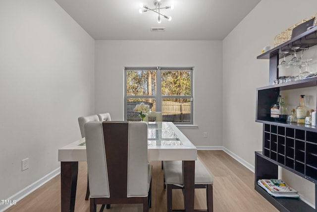 dining space with visible vents, baseboards, and wood finished floors