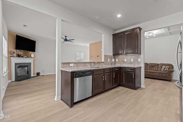 kitchen with dishwasher, dark brown cabinets, open floor plan, and backsplash