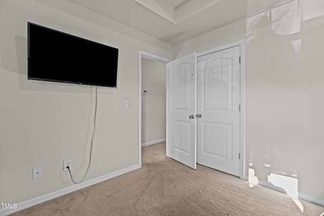 unfurnished bedroom featuring a closet, carpet flooring, and baseboards