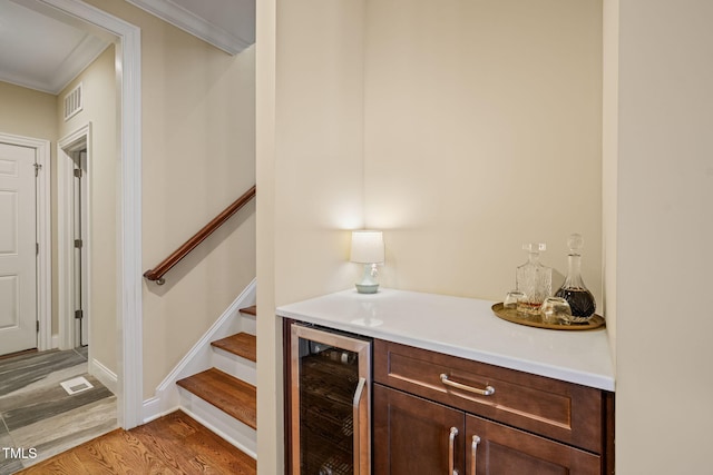 56 Mist Wood Ct, Pittsboro, NC 27312 - bar with beverage cooler, light wood finished floors, a bar, ornamental molding, and stairs