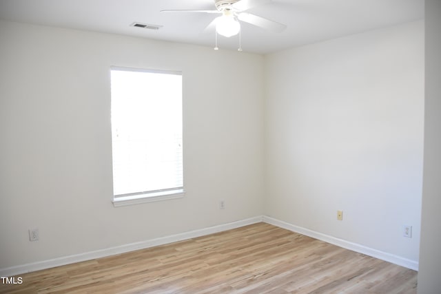 spare room featuring baseboards, light wood finished floors, visible vents, and a ceiling fan