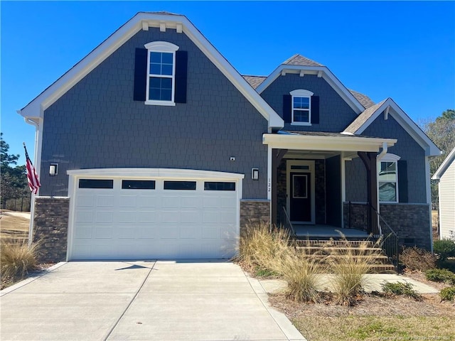 craftsman inspired home with a garage, stone siding, and concrete driveway