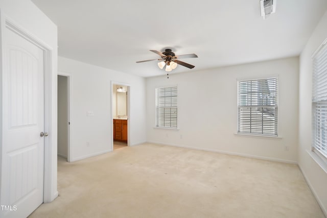 unfurnished bedroom with visible vents, light colored carpet, a ceiling fan, ensuite bath, and baseboards