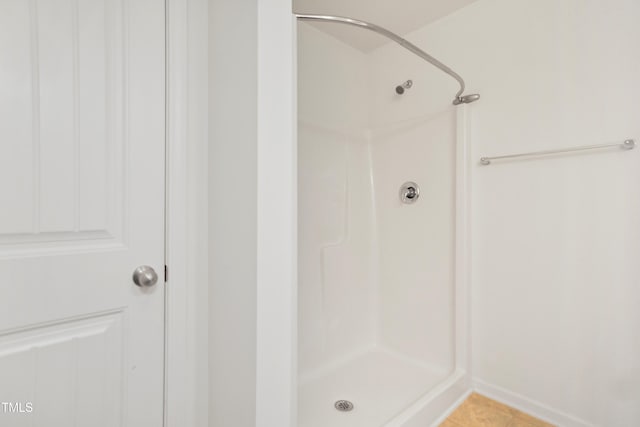 bathroom with a shower and tile patterned floors