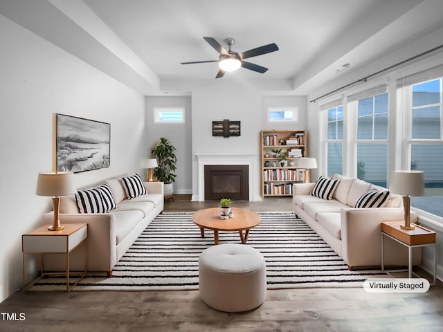 living room featuring dark wood-style floors, plenty of natural light, and a glass covered fireplace