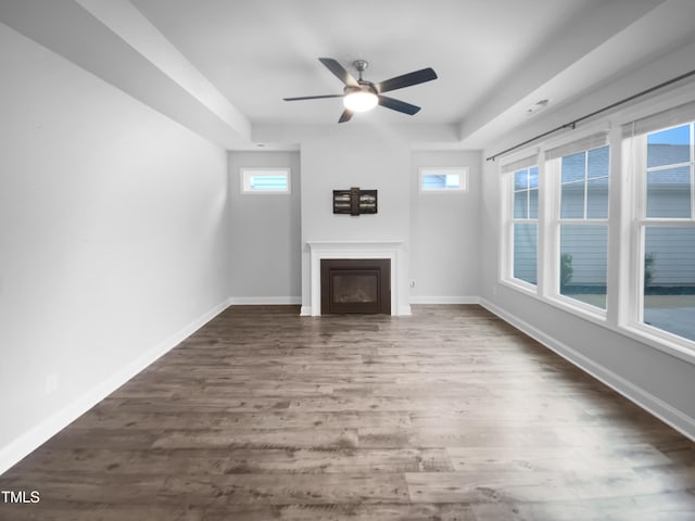 unfurnished living room featuring a fireplace, baseboards, and wood finished floors