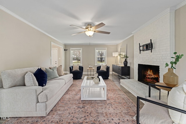 living area featuring ornamental molding, a fireplace, baseboards, and wood finished floors