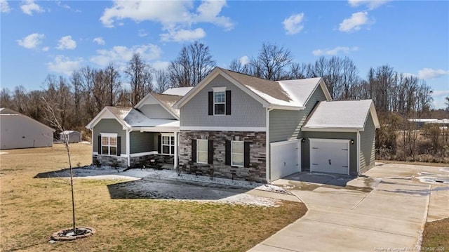 view of front of home with concrete driveway, a front lawn, an attached garage, and stone siding