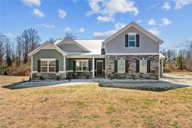 view of front of property featuring stone siding and a front lawn