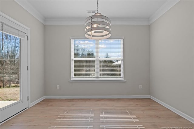 unfurnished dining area with light wood finished floors, visible vents, baseboards, and crown molding