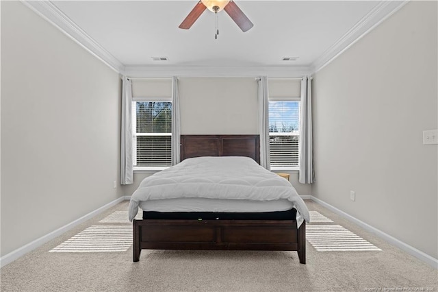 carpeted bedroom with a ceiling fan, visible vents, crown molding, and baseboards