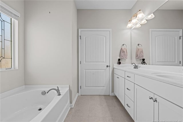 full bathroom featuring a bath, a wealth of natural light, tile patterned flooring, and a sink