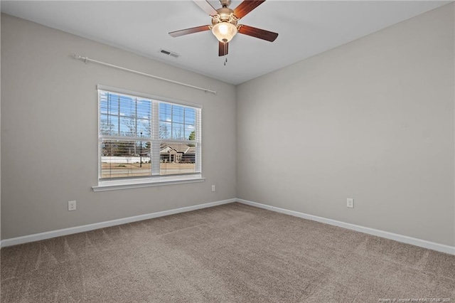 spare room with ceiling fan, carpet floors, visible vents, and baseboards