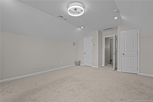 bonus room with light carpet, baseboards, visible vents, and vaulted ceiling