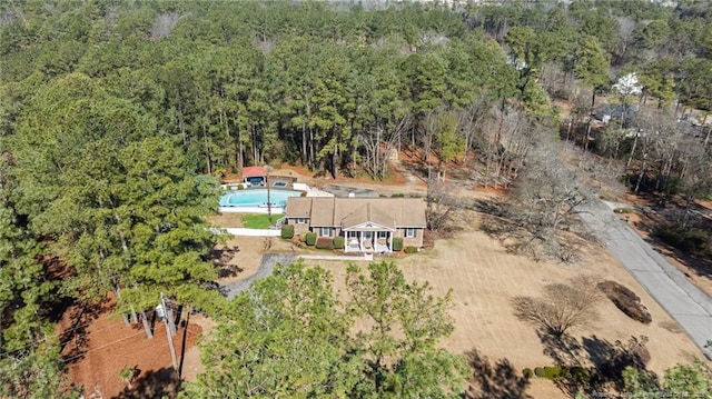 drone / aerial view featuring a wooded view