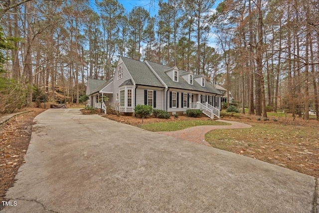 view of home's exterior with roof with shingles and driveway