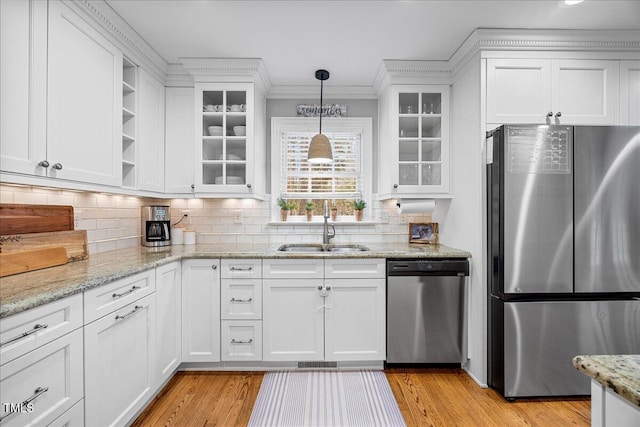 kitchen featuring a sink, white cabinets, appliances with stainless steel finishes, open shelves, and pendant lighting