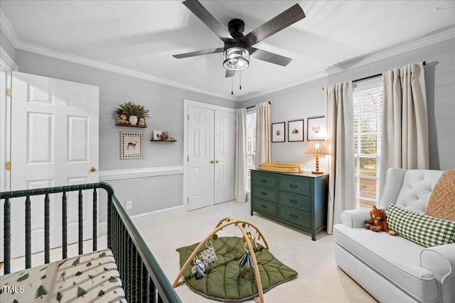 bedroom featuring baseboards, a ceiling fan, light colored carpet, crown molding, and a closet