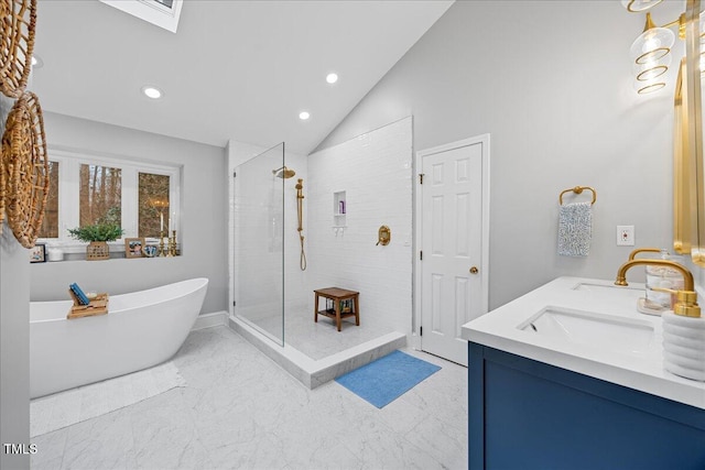 bathroom featuring a freestanding tub, a sink, vaulted ceiling, marble finish floor, and a shower stall