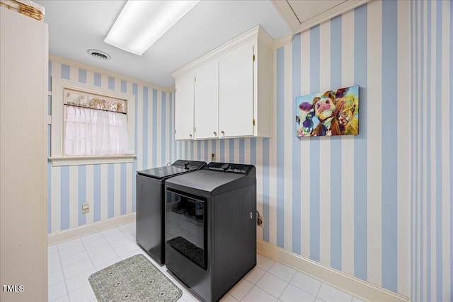 clothes washing area featuring light tile patterned floors, cabinet space, washer and dryer, baseboards, and wallpapered walls