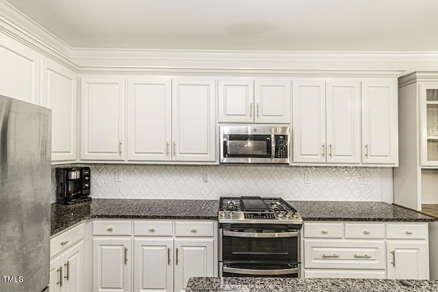 kitchen with backsplash, white cabinets, dark stone counters, and stainless steel appliances