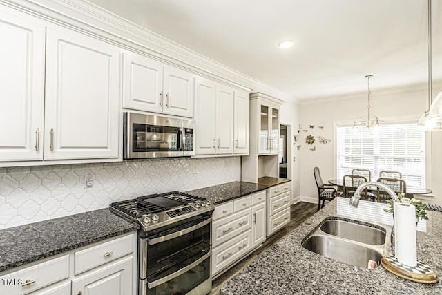 kitchen with a sink, tasteful backsplash, appliances with stainless steel finishes, and crown molding