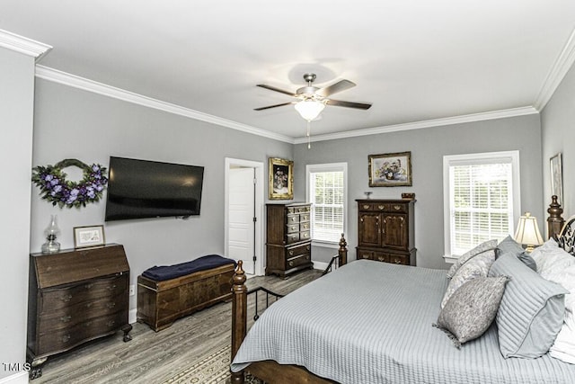 bedroom featuring crown molding, wood finished floors, baseboards, and multiple windows
