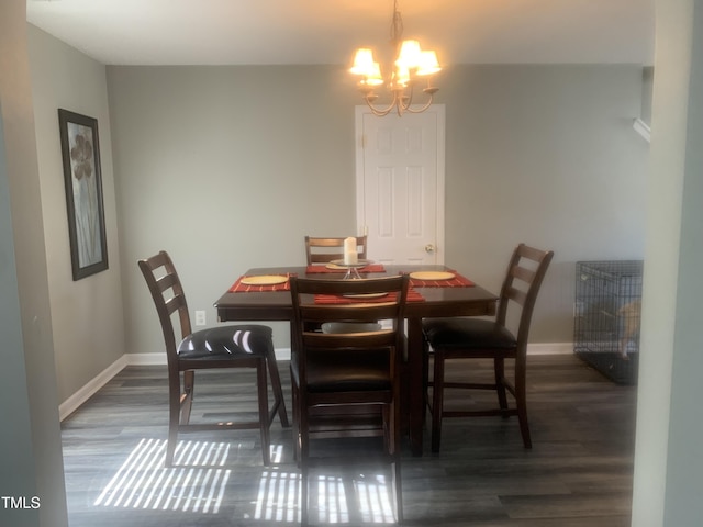 dining area featuring a notable chandelier, baseboards, and wood finished floors