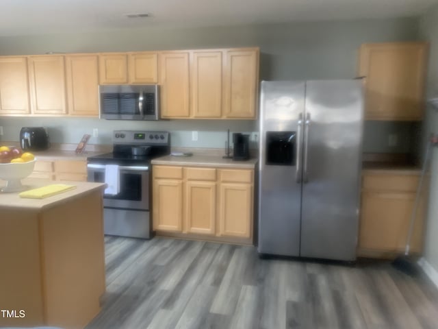 kitchen with appliances with stainless steel finishes, light countertops, and light brown cabinets