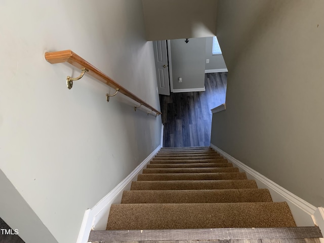 stairway featuring baseboards and wood finished floors