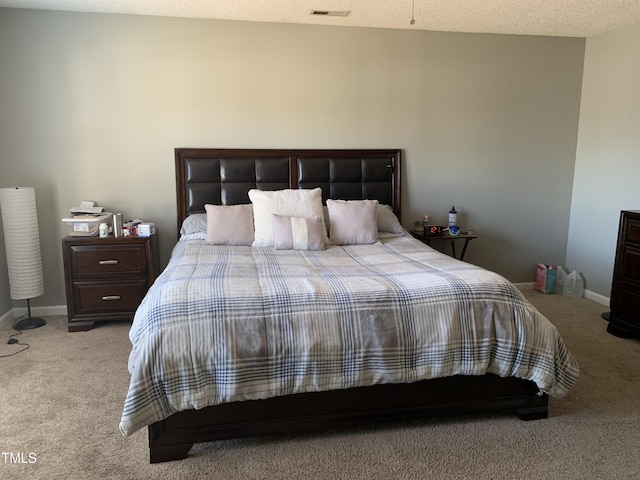 bedroom with carpet, visible vents, a textured ceiling, and baseboards