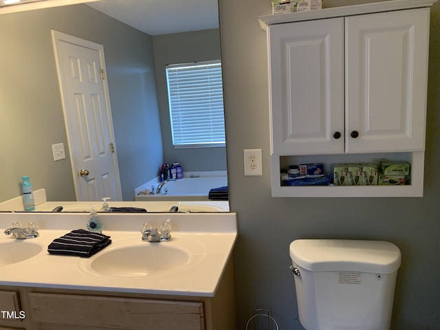 bathroom featuring double vanity, toilet, and a sink