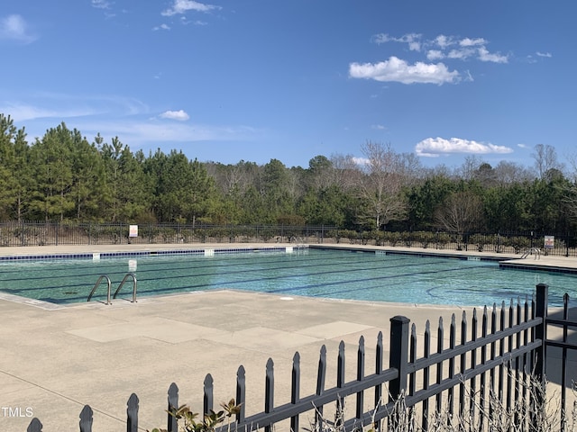 community pool featuring a patio and fence