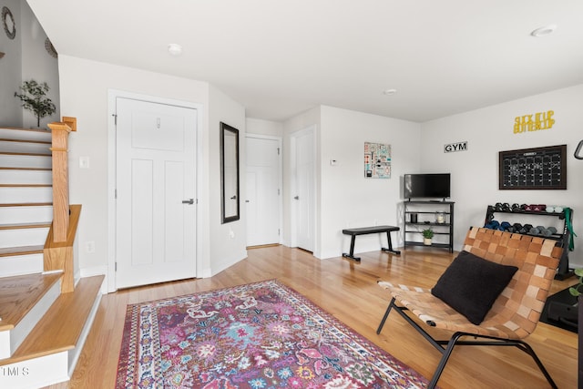 living room with stairs, baseboards, and wood finished floors