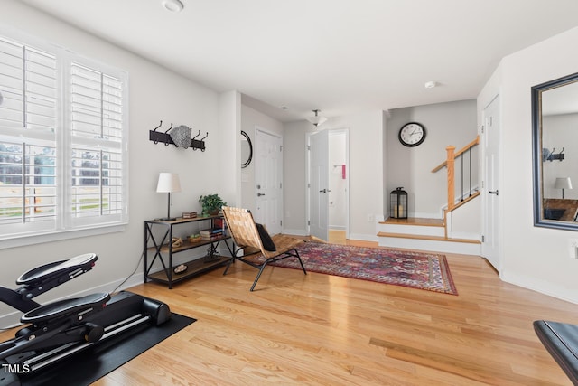 interior space with stairs, baseboards, and wood finished floors