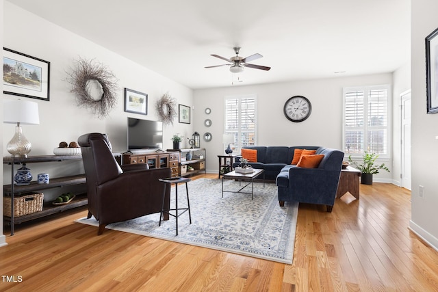 living room featuring a ceiling fan, a healthy amount of sunlight, light wood-type flooring, and baseboards