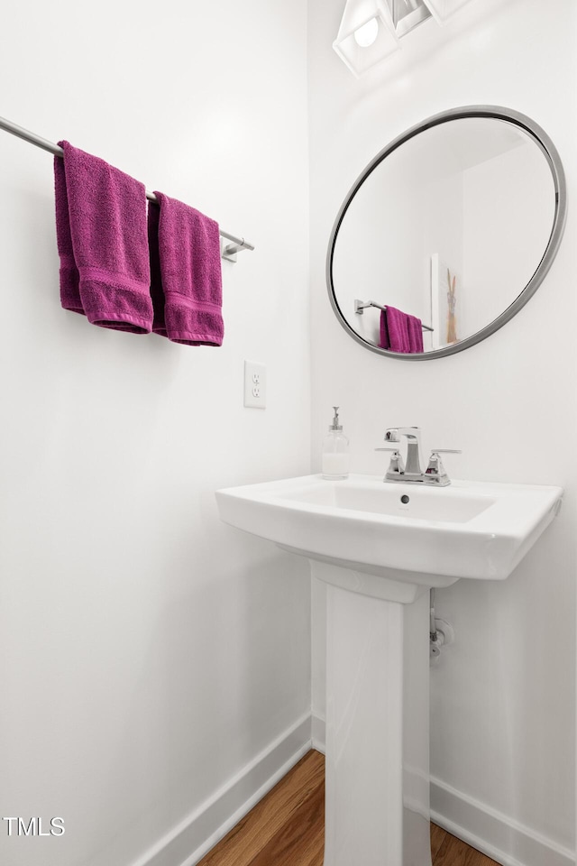 bathroom with baseboards and wood finished floors