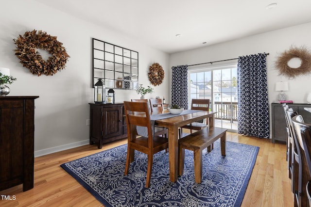 dining area featuring light wood-type flooring and baseboards