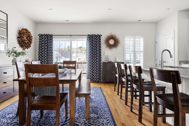 dining area with light wood-style floors and a healthy amount of sunlight