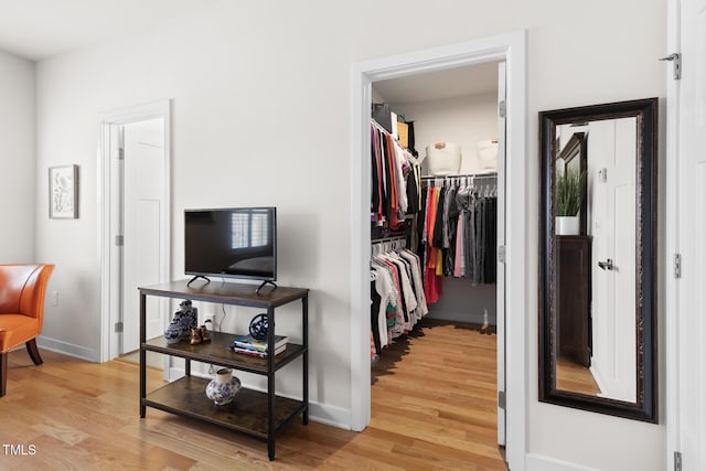 walk in closet with light wood-type flooring