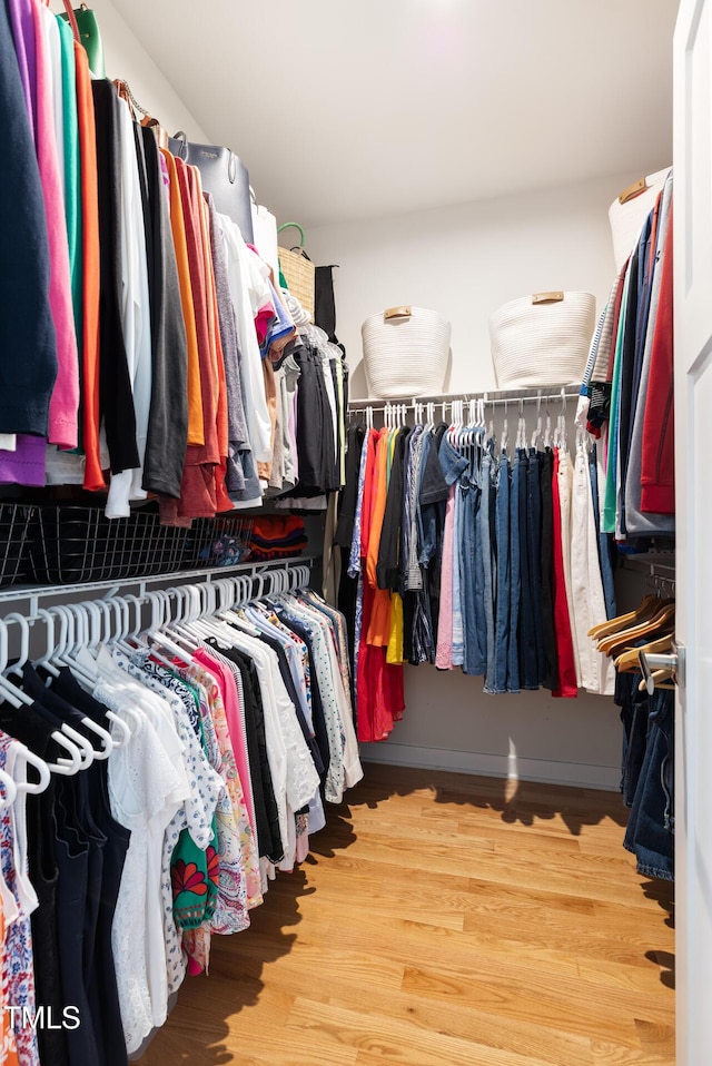 walk in closet with wood finished floors